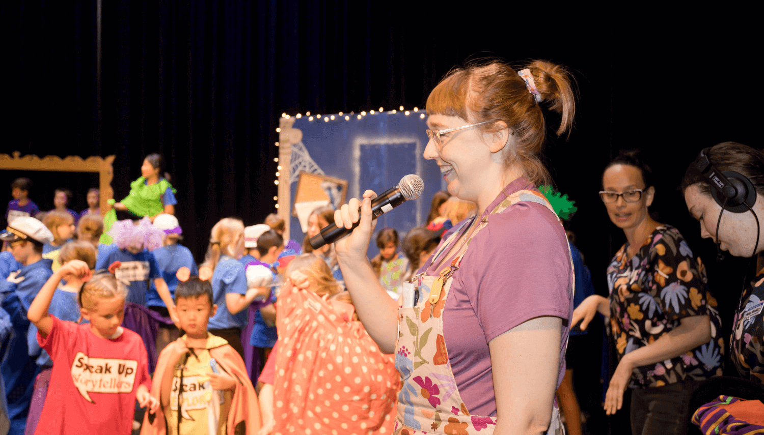 Miss Cathy holding a microphone at the speak up concert